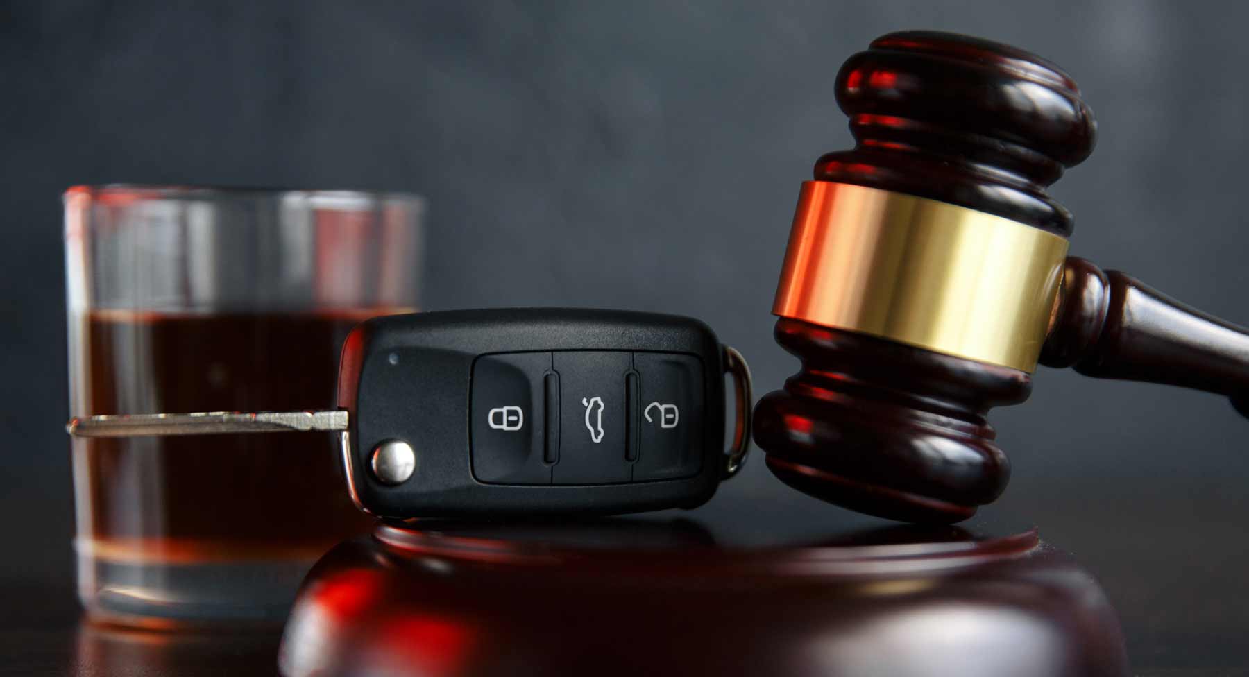 Alcoholic beverage, car keys, and a judge's gavel to denote legalities of drinking and driving