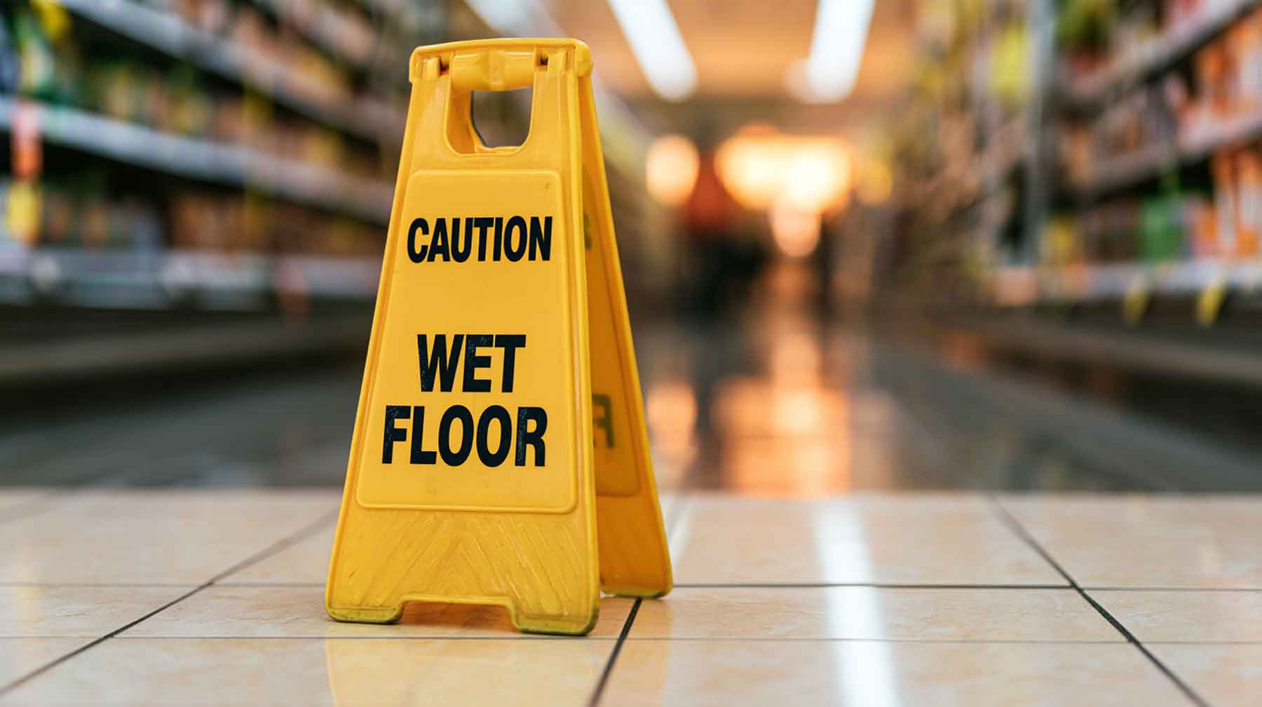 California premises liability law Wet floor caution sign in a store aisle, illustrating California premises liability law